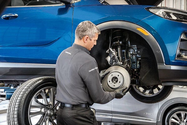 A person checking brakes of car