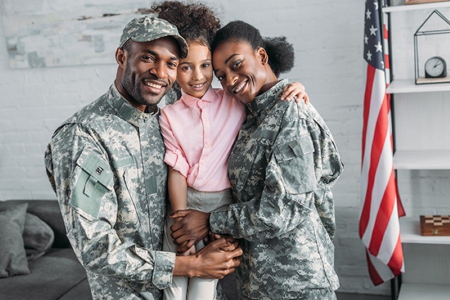 Military Couple and their Daughter Standing in front of Wall